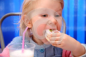 Child eats cake in cafe