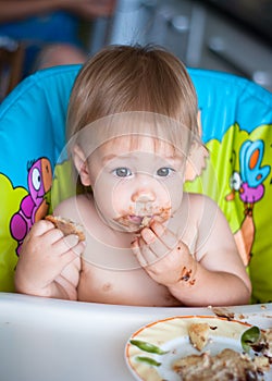 Child eats cake in the highchair