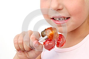 Child eats candy. Girl has caries on teeth