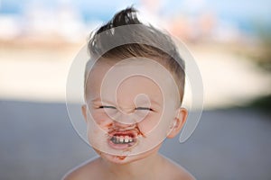 Child eats chokolate with full stength on a beach