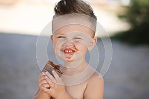 Child eats chokolate with full stength on a beach