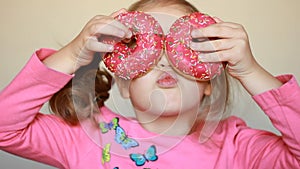 Child eats donut. Closeup baby girl eating doughnut with glase. Delicious, sweet, sweettooth.