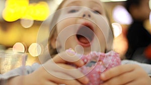 Child eats donut. Closeup baby girl eating doughnut with glase. Delicious, sweet, sweettooth.