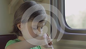 A child eats lunch sitting in a train compartment while traveling