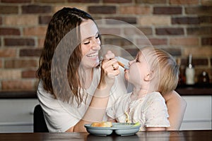Child eats a mixture of purees,mom feeds the baby healthy food from a spoon.Healthy eating,complementary feeding,weaning