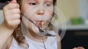 Child eats pasta with sauce. Baby girl eating pasta for lunch. Food close up.