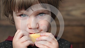 A child eats a piece of cheese
