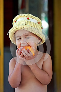 The child eats a tasty peach