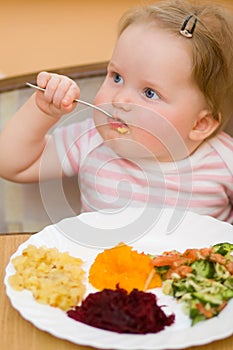 The child eats a vegetable salad