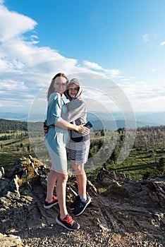 A child embraces mom in the mountain trip