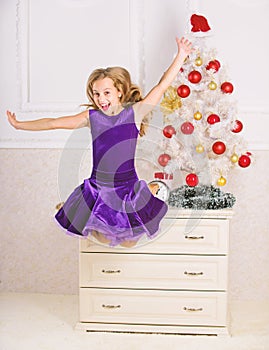 Child emotional cant stop her feelings. Girl in dress jumping. It is christmas. Day we have waited for all year finally
