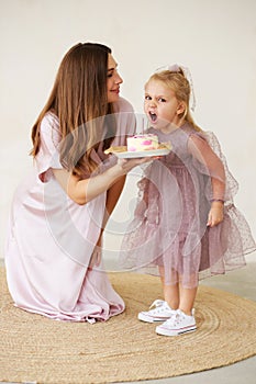 Child is emotionally eating a birthday cake. Birthday celebration.