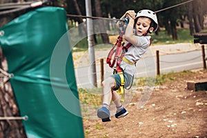 Child enjoying activity in a climbing adventure park on a summer day
