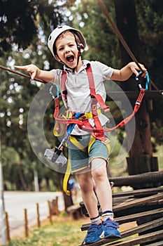 Child enjoying activity in a climbing adventure park on a summer day