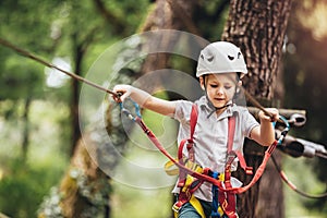 Child enjoying activity in a climbing adventure park on a summer day