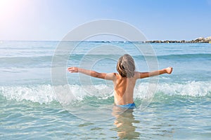 Child enjoying sun and waves