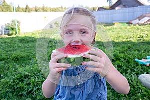 The child enjoys eating delicious, red, ripe, juicy, appetizing watermelon.