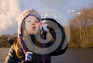 Child enjoys playing with soap bubbles at sunset photo