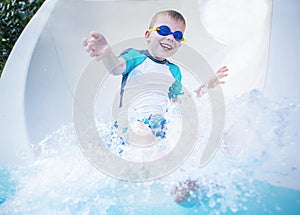 Child excited and having fun going down a waterslide