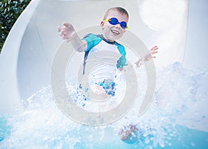 Child excited and having fun going down a waterslide photo