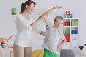 Child exercising with female physiotherapist