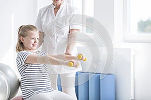 Child exercising with yellow dumbbells