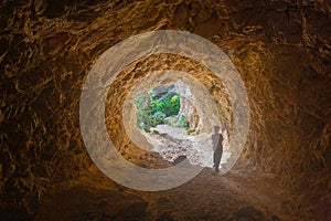 Child exiting Cala Blanca cave, Ibiza, Spain