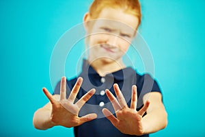 Child expresses denial by pulling his hands into the camera, showing repulsion or rejection.