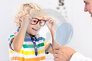 Child at eye sight test. Kid at optitian. Eyewear for kids.