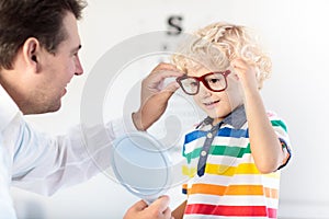 Child at eye sight test. Kid at optitian. Eyewear for kids.