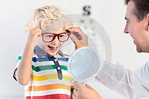 Child at eye sight test. Kid at optitian. Eyewear for kids.