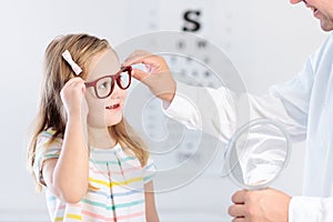 Child at eye sight test. Kid at optitian. Eyewear for kids.