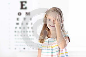 Child at eye sight test. Kid at optitian. Eyewear for kids. photo