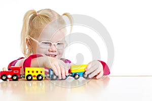 Child in eyeglasses playing toy train isolated photo