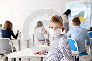 Child with face mask back at school after covid-19 quarantine and lockdown.