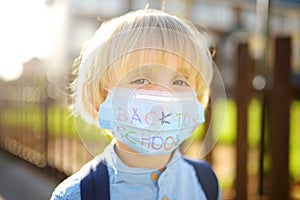 Child in face mask going at reopen school after covid-19 quarantine and lockdown. It is new normal for protection and prevention