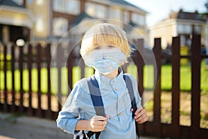 Child in face mask going at reopen school after covid-19 quarantine and lockdown. It is new normal for protection and prevention