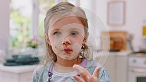 Child, face and messy eating chocolate after baking in the kitchen for sweet, delicious treat. Dirty, hungry kid and