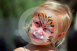 Child with face painted like tiger