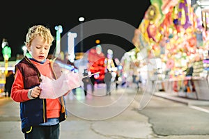 Child at a fair enjoying a large cotton candy cloud