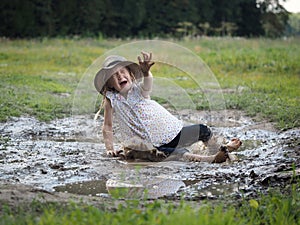 Child falls in a puddle. Field.