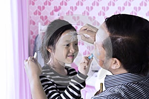 Child and father doing face painting