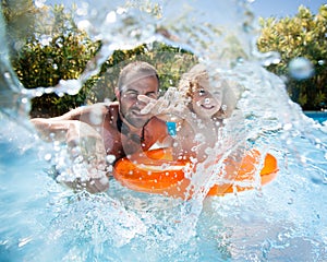 Child with father in swimming pool