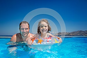 Child with father in swimming pool