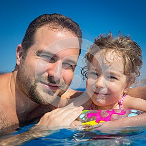 Child and father in swimming pool
