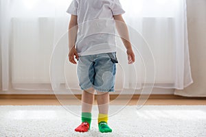 Child feet with different socks standing in rows, kids wearing different socks