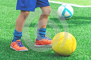 Child feet dribbling Soccer ball on a field