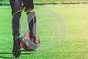 Child feet dribbling Soccer ball on a field