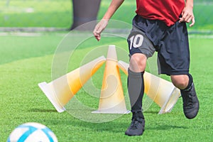 Child feet dribbling Soccer ball on a field