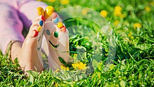 Child feet on the grass drawing a smile. Selective focus.